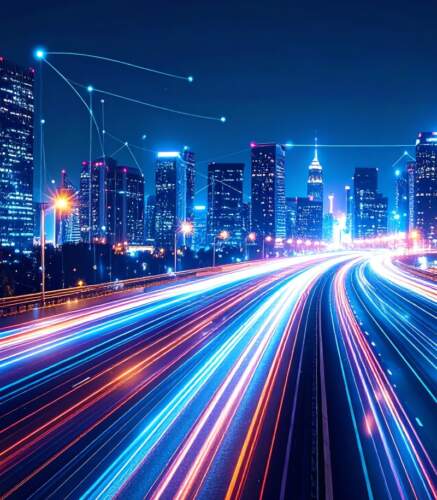 Vues nocturnes d'une ville avec des lumières vives et des lignes lumineuses sur la route, illustrant le dynamisme technologique.