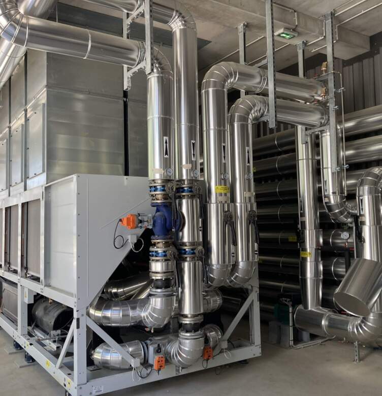 Metal ventilation system and cooling equipment in a data center, featuring stainless steel pipes and industrial design.