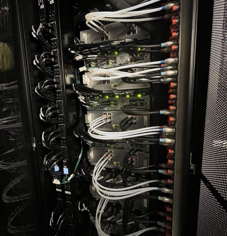 Serveur de datacenter avec plusieurs équipements, câbles noirs et lumineux, mettant en avant une organisation complexe et technologique.